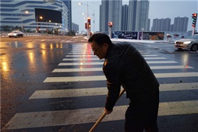 霓虹灯下的扫雪税务人